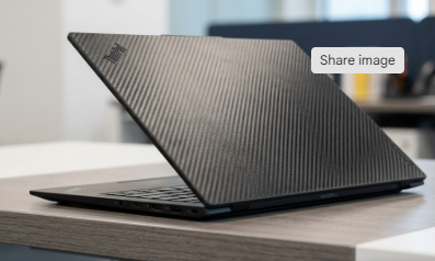 A profile view of the slim Lenovo ThinkPad X1 Carbon Gen 13 Aura Edition showcasing its carbon fiber finish.
