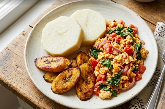 A healthy meal display showing upgrading boiled yam and plantain with fresh vegetable egg sauce.