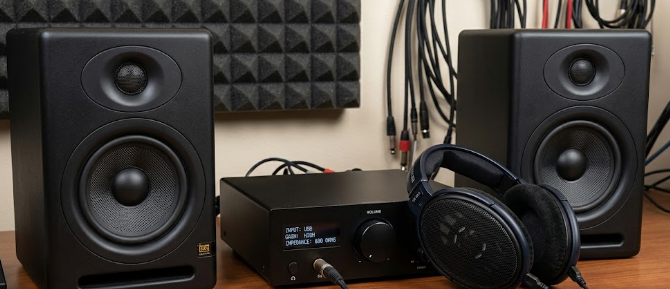 A pair of studio monitors demonstrating high-Z over-ear headphone impedance next to a dedicated desktop amplifier.