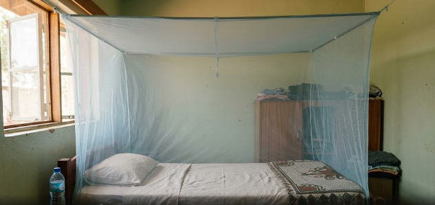 A bed protected by an insecticide-treated net for practical malaria prevention.